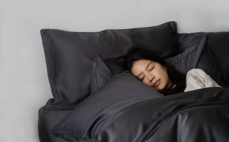 girl_sleeping_on_slate_grey_bed_sheets_